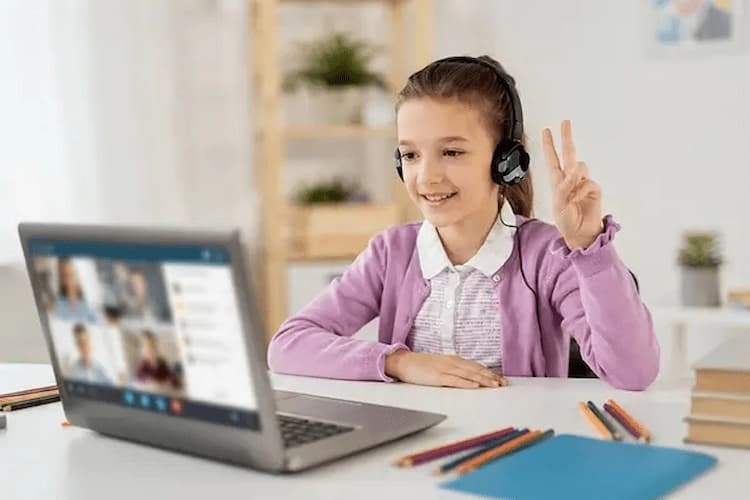 Kulaklıkla online İngilizce dersi alan mutlu çocuk